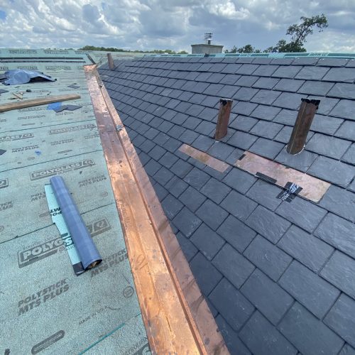 Slate roof installation with copper flashing